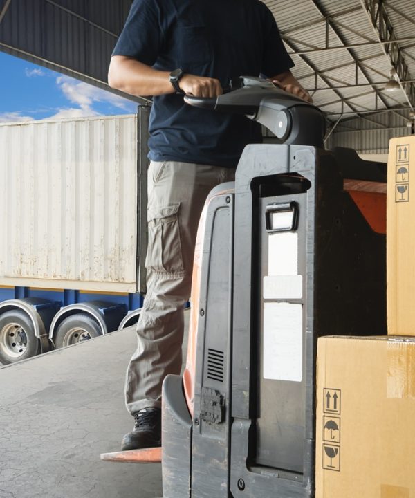 warehouse-worker-driving-forklift-pallet-jack-unloading-pallet-goods